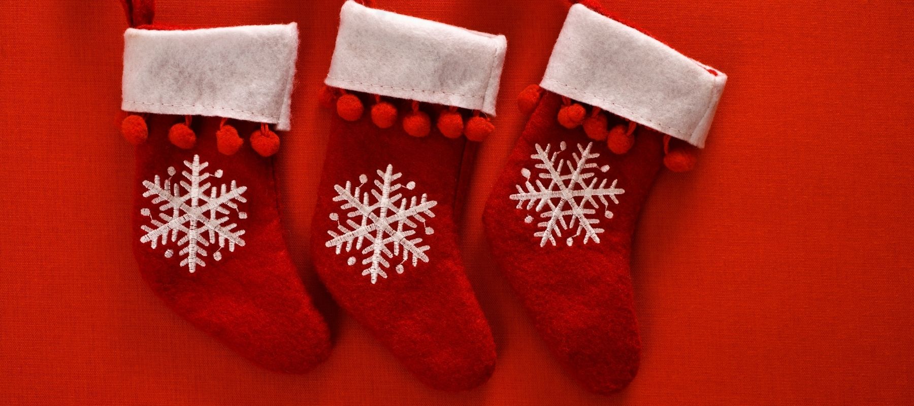 Festive red and white stockings pinned against a bright red background
